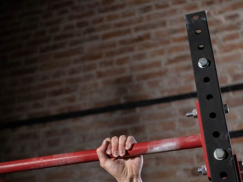 Close up of a man hands gripping a pull up bar showing determination and strength